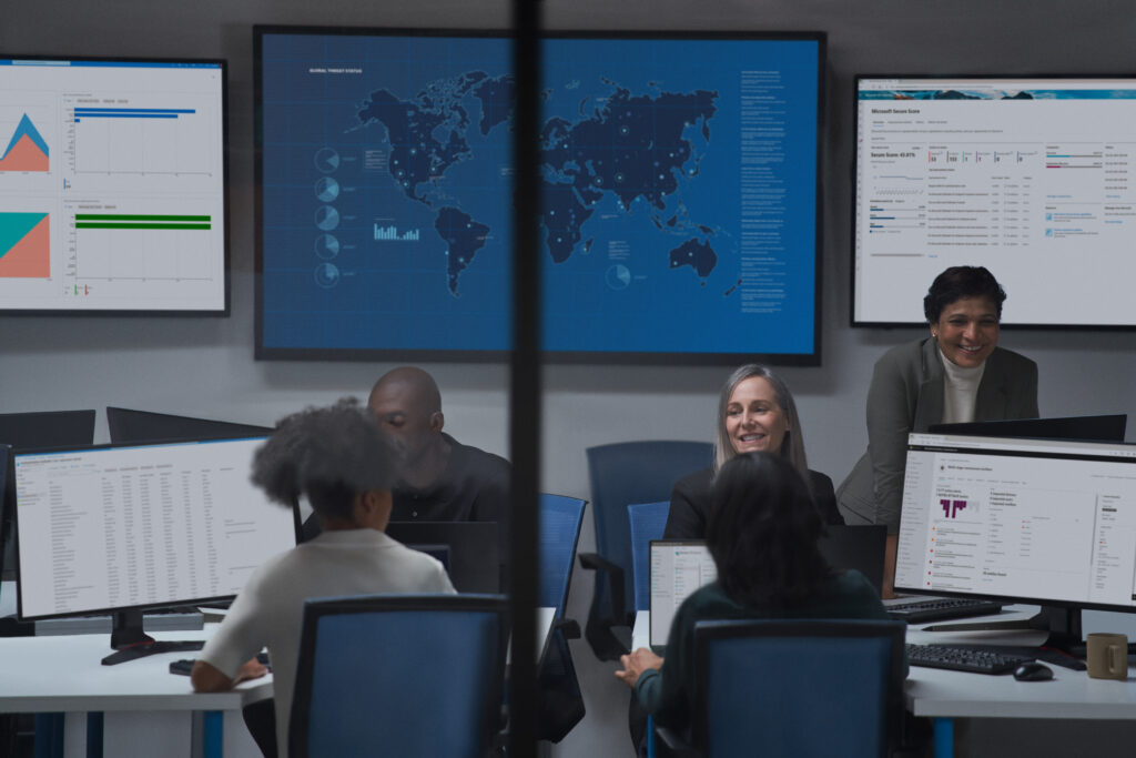 a group of people sitting at a desk in front of a computer