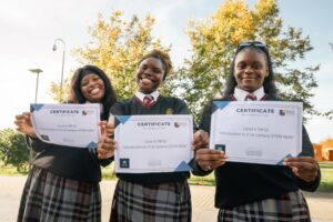 Three students holding up certifications