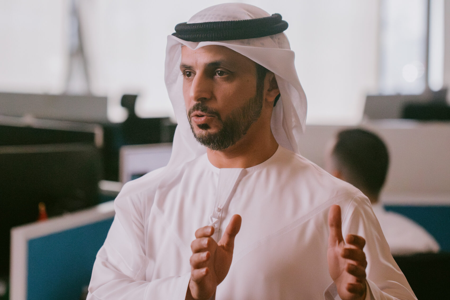 A portrait of a bearded man in traditional Emirati headgear.